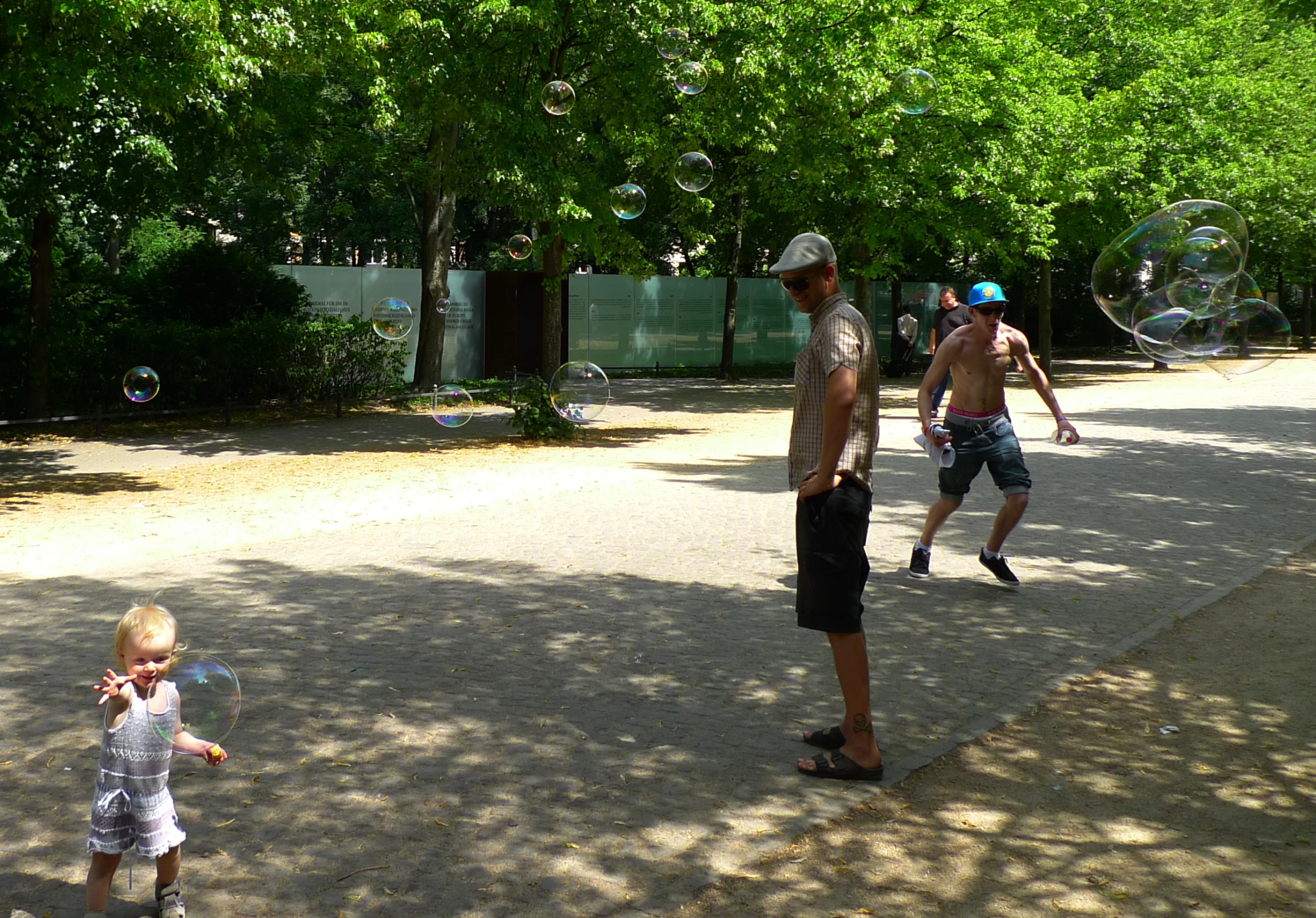 two men standing on the side of a street with a small child