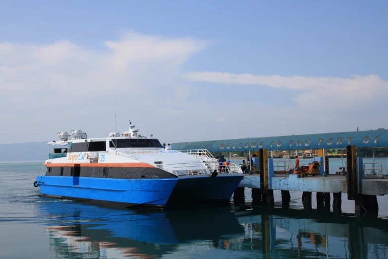 a large boat docked on a lake near a dock