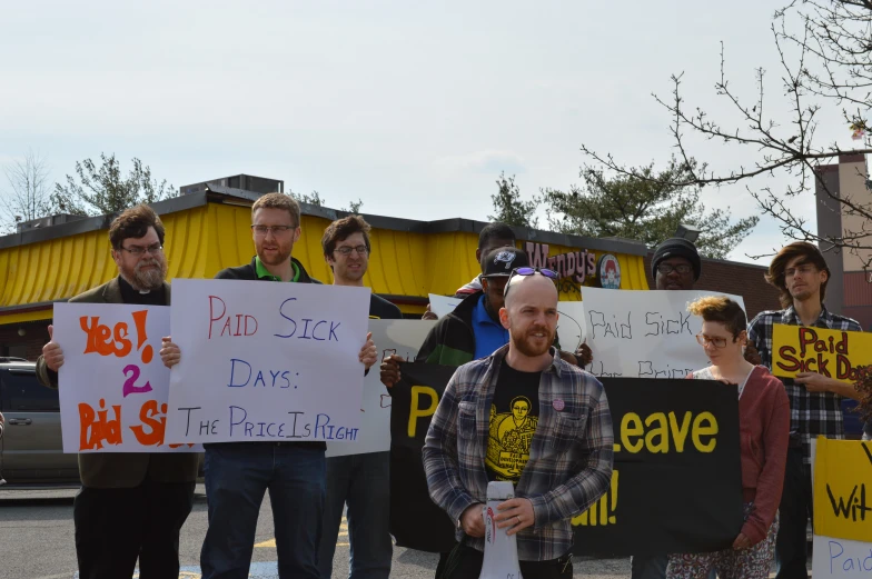 protesters holding signs protesting outside of a store