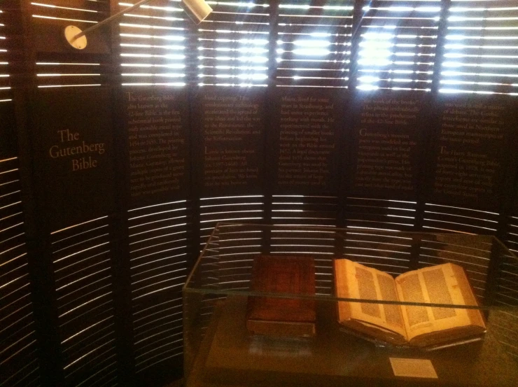 a wooden book is on display in a glass case