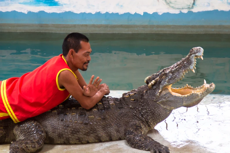 a man that is sitting on top of a big alligator