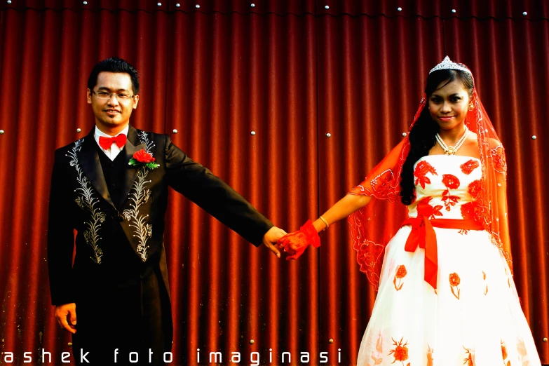 a couple dressed in traditional costumes and holding hands