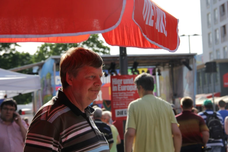 man standing under an umbrella in a crowded area