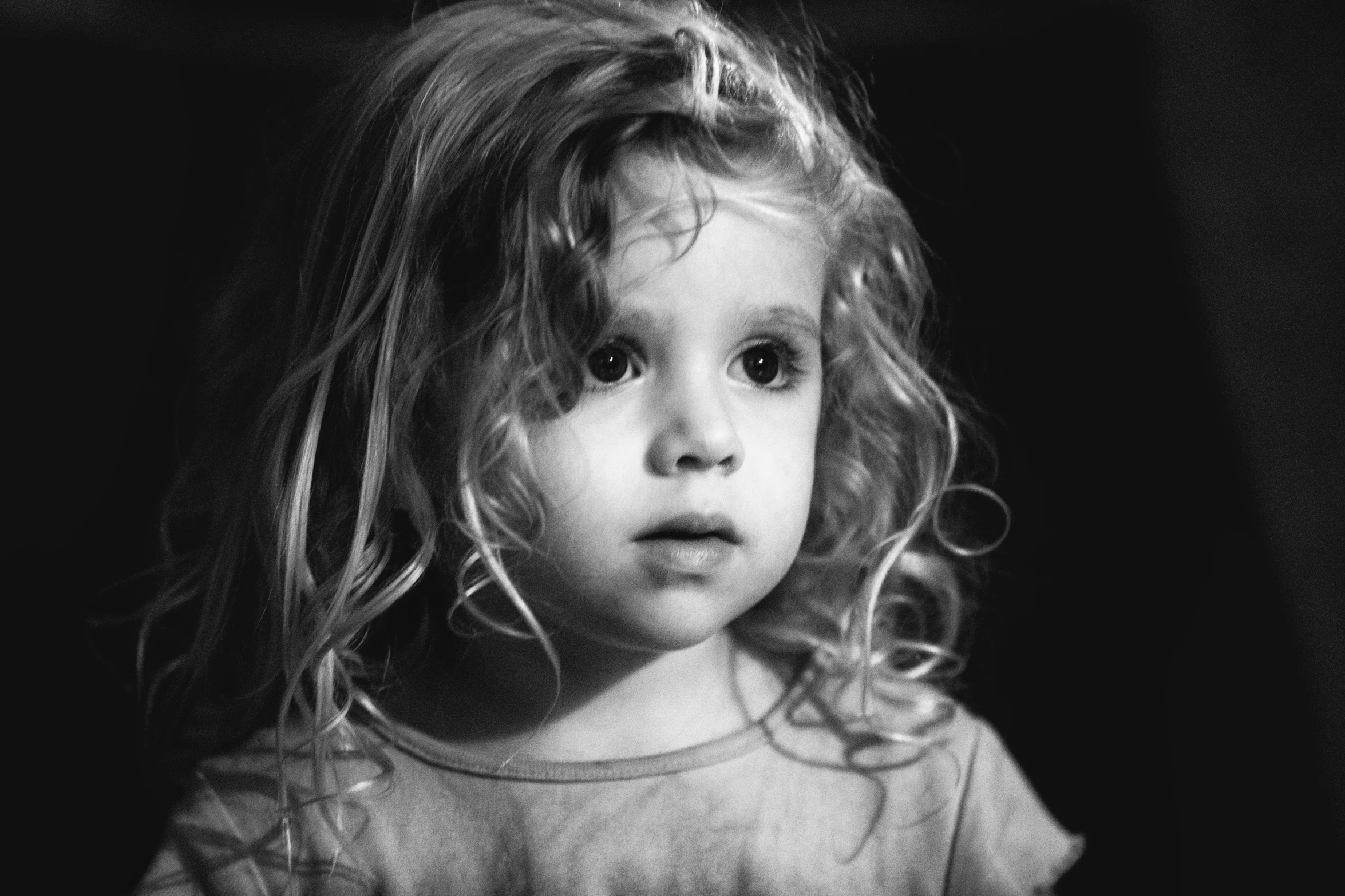 a black and white po of a child with curly hair