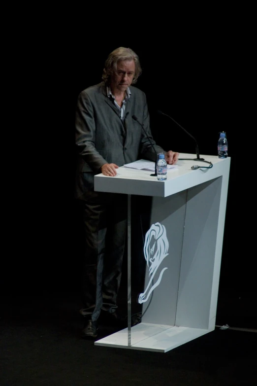 a man standing at a podium at a black event