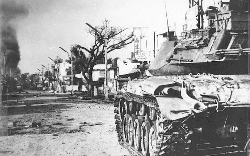 old tanks in dirt area with trees and buildings