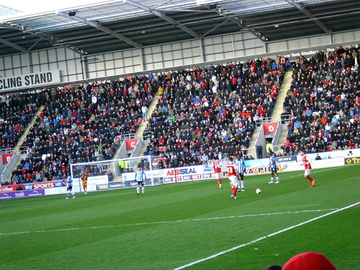 a crowded stadium with several players playing soccer