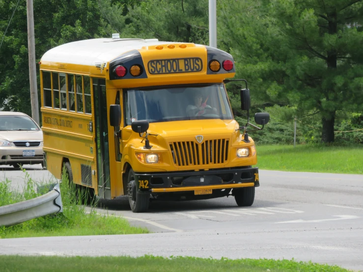 a yellow school bus driving down a road