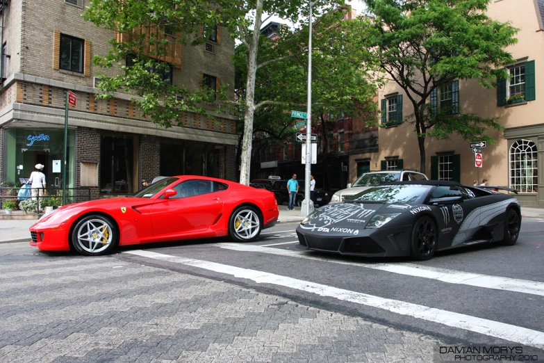 two sports cars are parked in the street