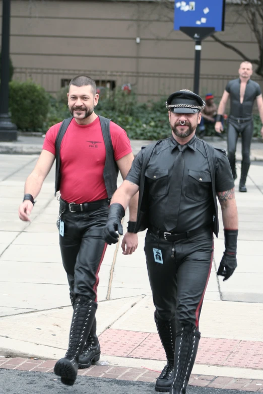 two men wearing leathers walking down the street