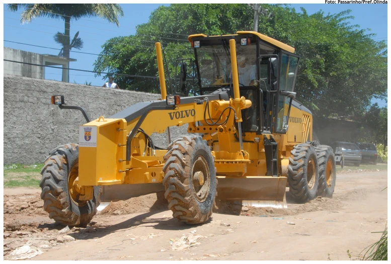 a yellow tractor is parked in the dirt