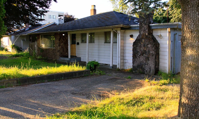 an old brick house with the door open and a fire hydrant in front of it