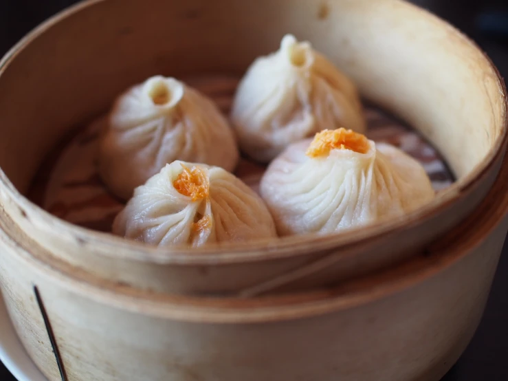 some asian dumplings in a bamboo container