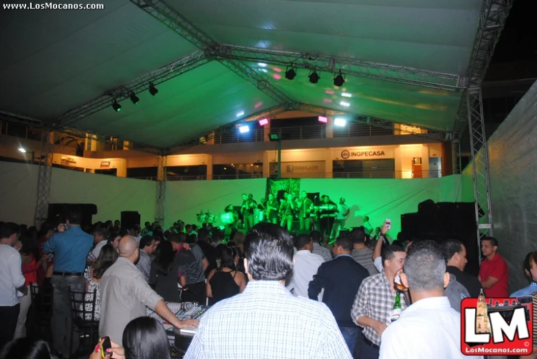 a large group of people are gathered under a tent