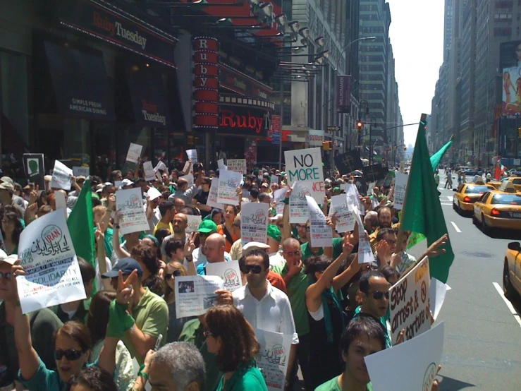 large group of people marching down a city street