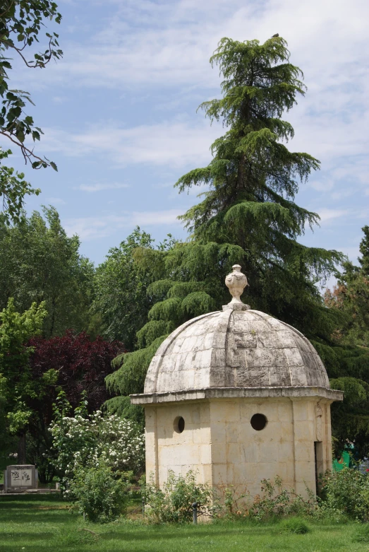 an old brick structure in the park that has a white painted dome