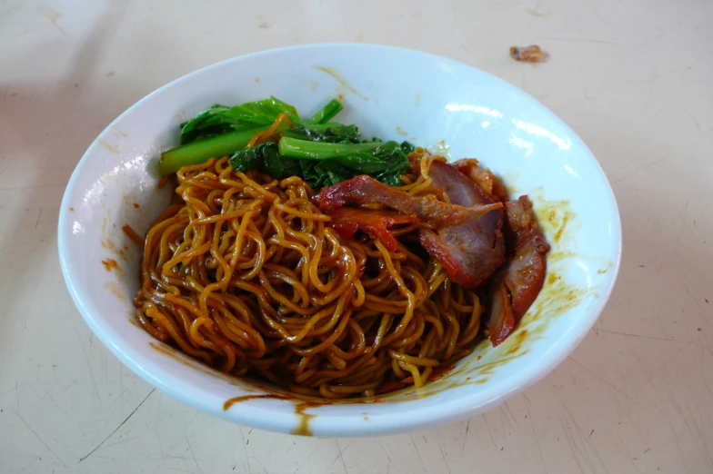 the bowl has meat, noodles and broccoli in it