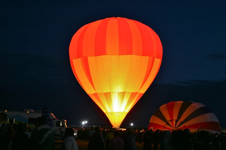 a large group of people flying a large light up balloon