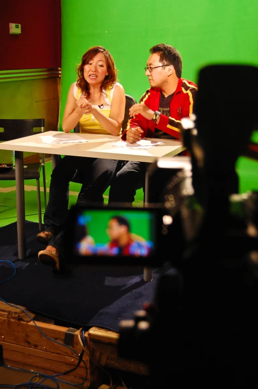 a woman and man in a video studio on a green screen