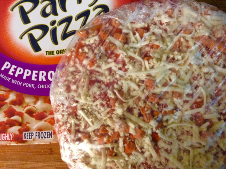 a variety of pizza's in plastic bags on the counter