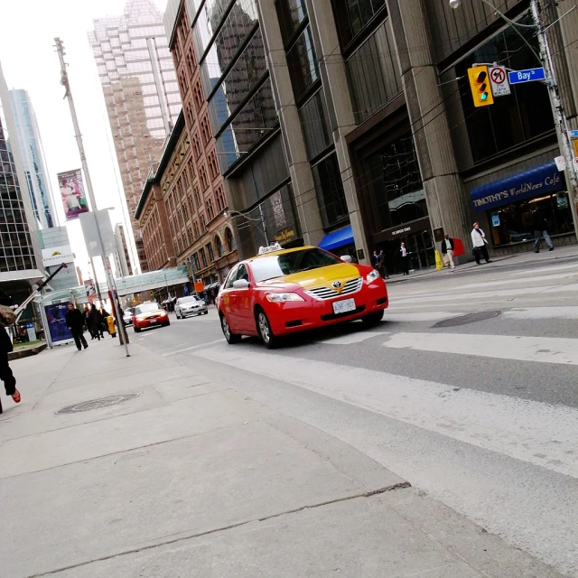 a car in the street next to some very large buildings