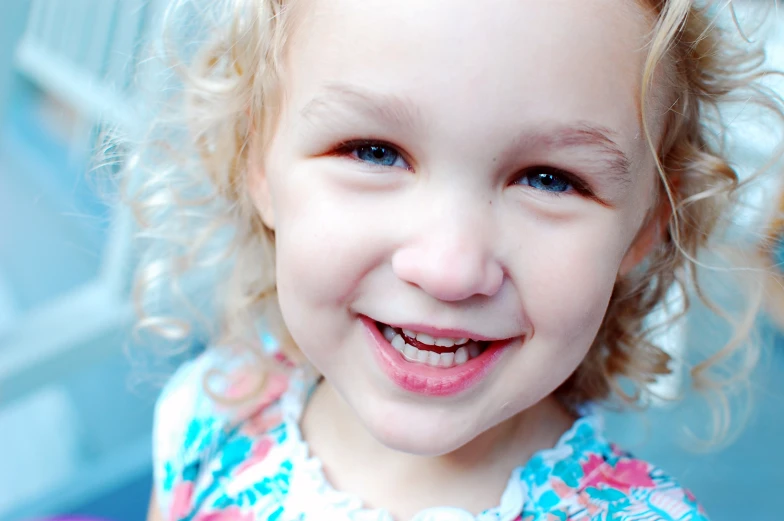 the young child is smiling and wearing a colorful dress