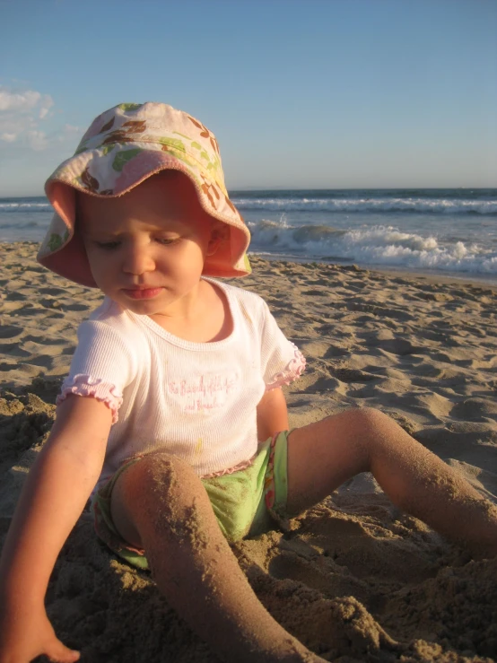 a young child playing in the sand on the beach