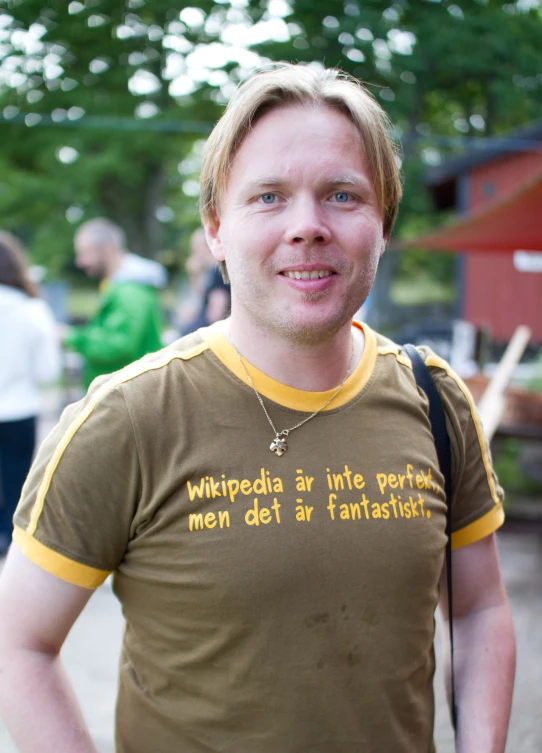 a guy wearing an ugly t shirt saying'wikipedia'in german