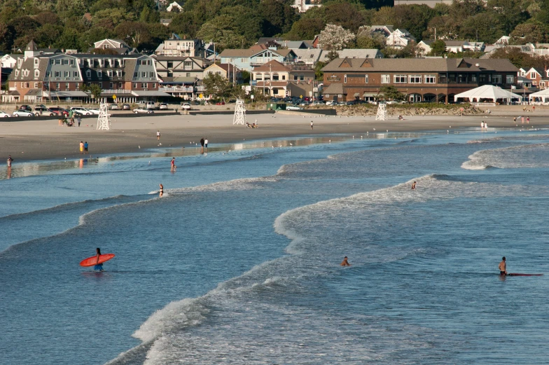 people on the beach with houses behind them