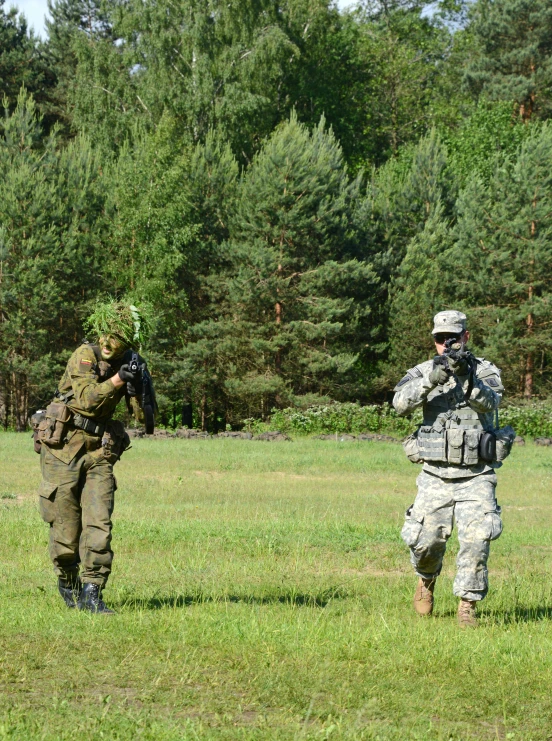 two soldiers dressed in military attire and walking through an open field