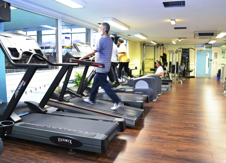 people are running on exercise machines at the gym