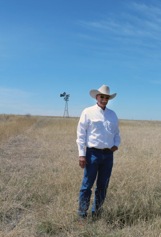 a man standing in the middle of an open prairie