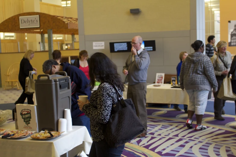 some people standing in a hall with food and drinks