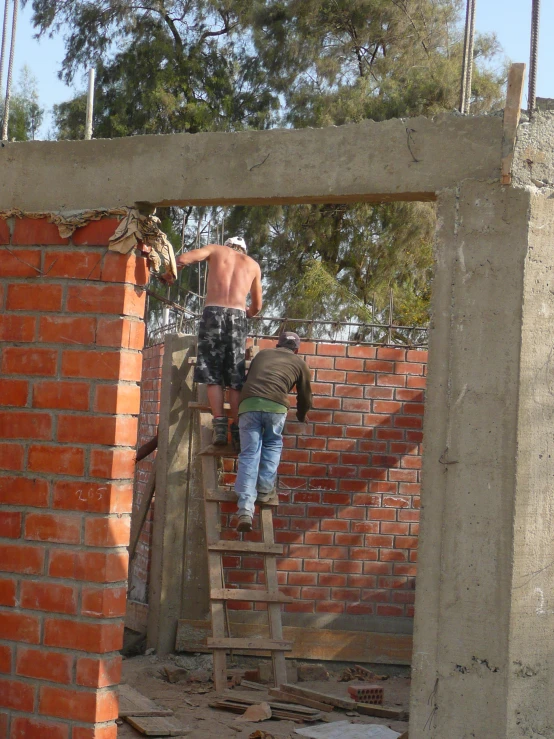 two men on a wooden platform working on brick walls