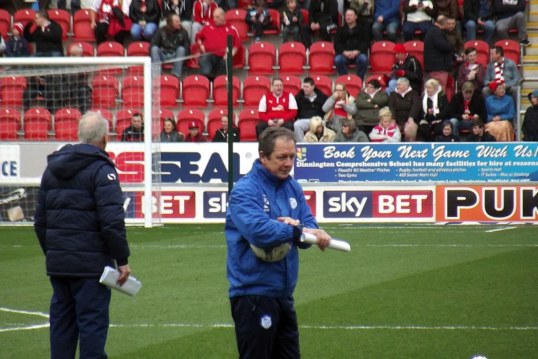 two men are standing on a field while watching a game