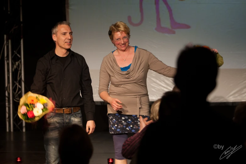 two people holding hands while a man walks down the aisle