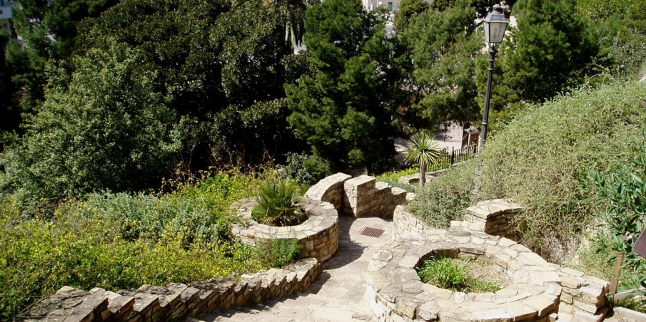 a small park has a cement bench and grass