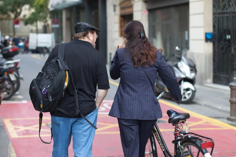 a woman in a black jacket walks and talks on her phone