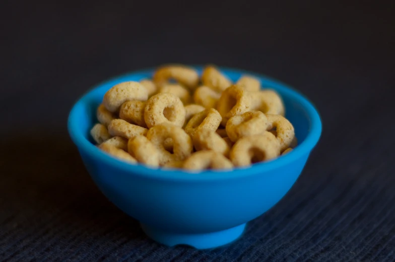 a blue bowl filled with cereal on top of a black table