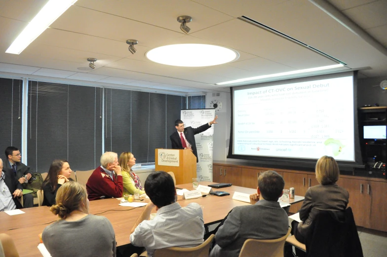 people in chairs with one person giving a presentation