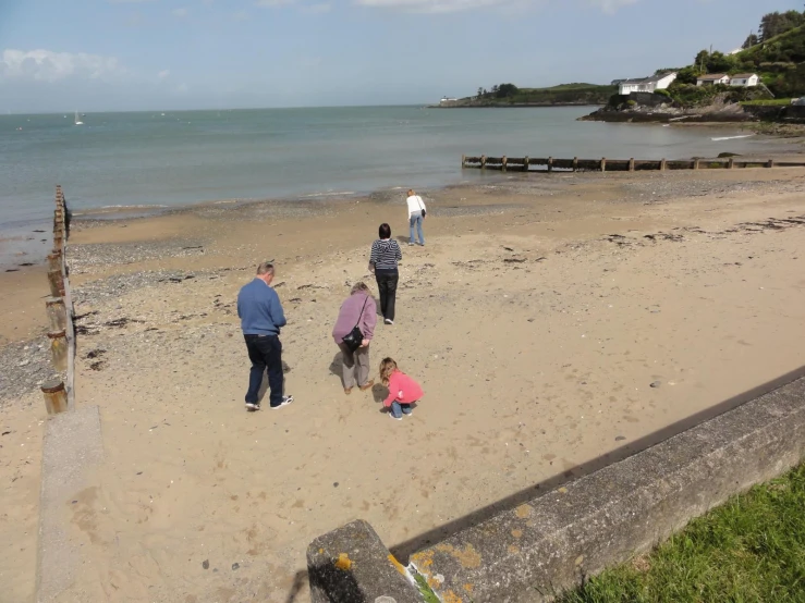 several people at the beach in the sun, one of which has a white frisbee