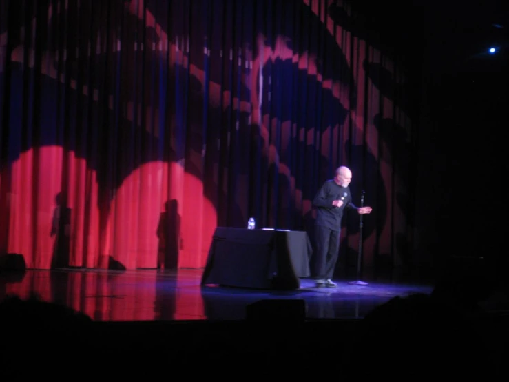 a man standing on a stage holding a microphone