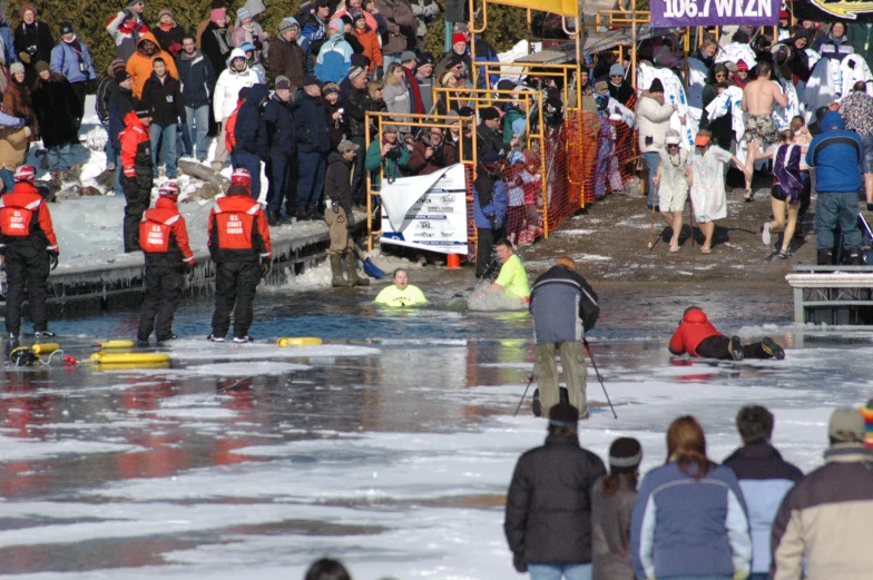 there are several people standing on the ice and playing with water