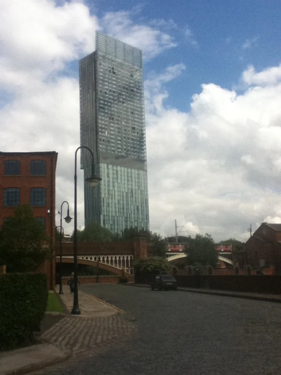 a street scene with focus on a building and cloudy sky