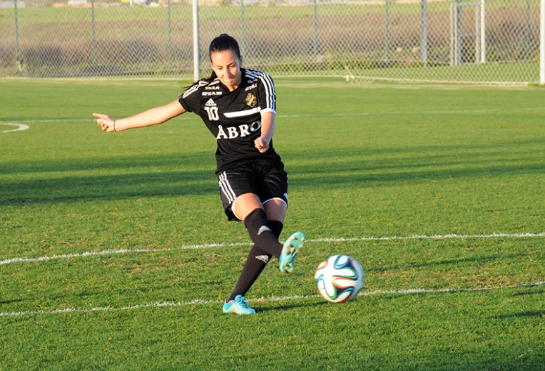 a female soccer player in action on the ball