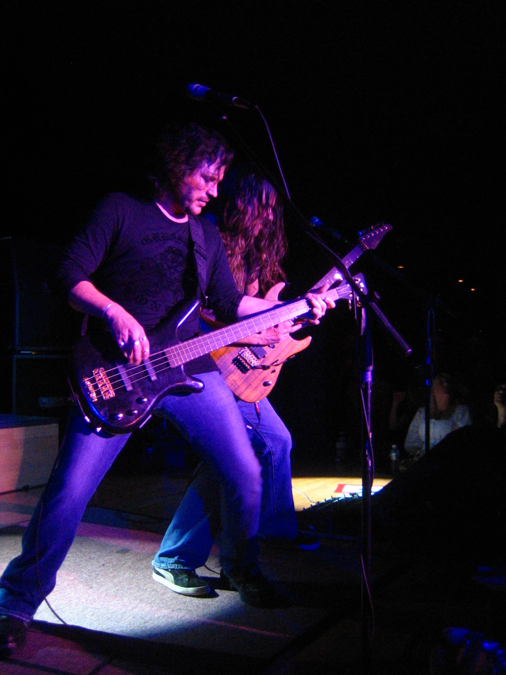 a young man playing a guitar next to a woman