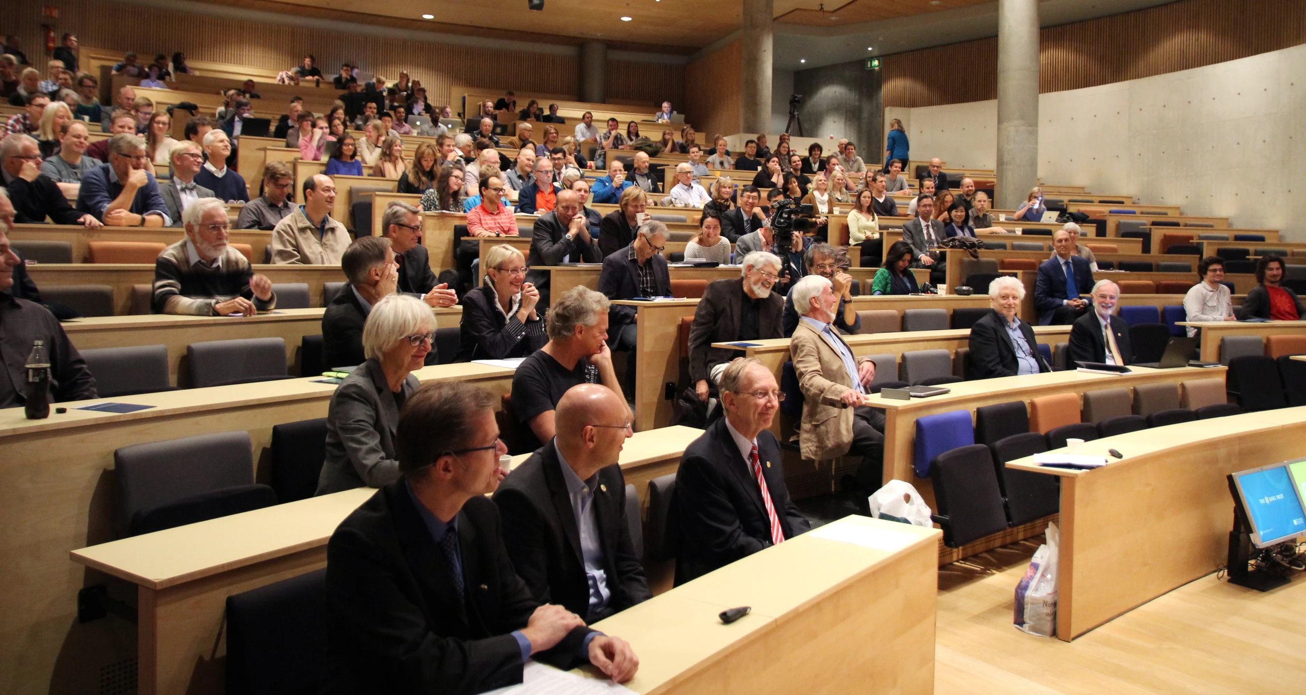 an empty auditorium filled with people and rows of chairs