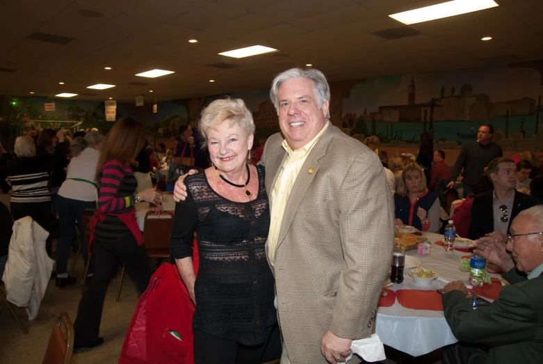 a man and woman posing for the camera in a restaurant