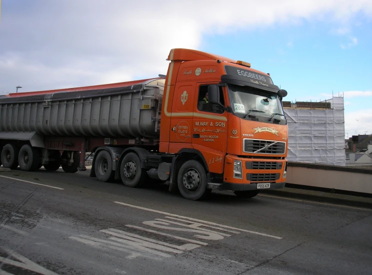 a truck sitting on a road with a person standing in the back