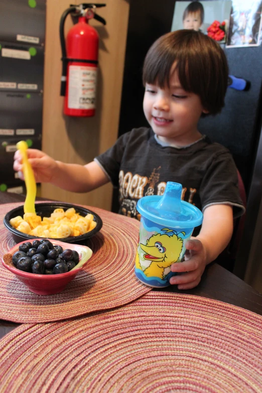 a child sitting at a table with food in bowls